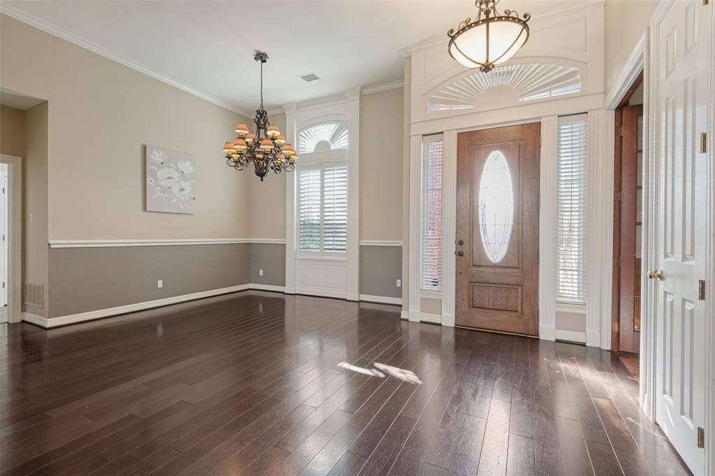 2704 Horsehead Crossing, Southlake, TX 76092 Entryway featuring wood-finish flooring, two-tone wall detailing, arched transom windows, iron chandelier, and a decorative glass-panel front door