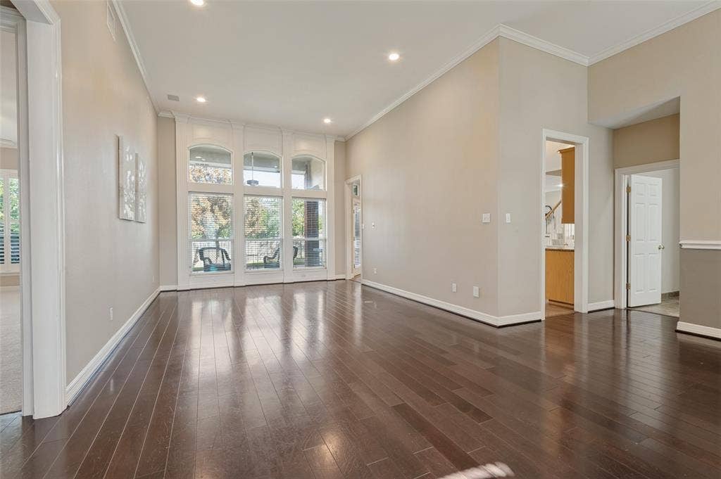 2704 Horsehead Crossing, Southlake, TX 76092 Open-concept living space featuring high ceilings, wood-finish flooring, recessed lighting, and expansive floor-to-ceiling windows with crown molding