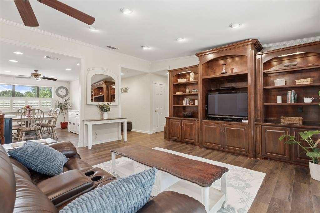 Built-in media center with shelving, wood-finish flooring, recessed lighting, and ceiling fan