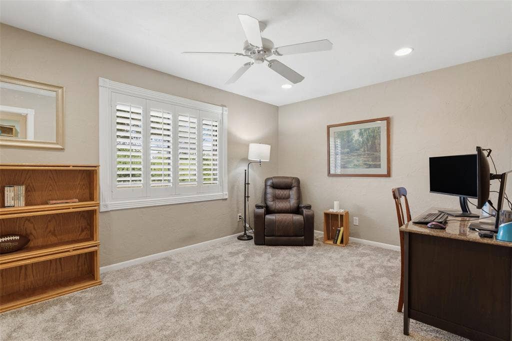 Recessed lighting, ceiling fan, white plantation shutters, and light-toned wall paint