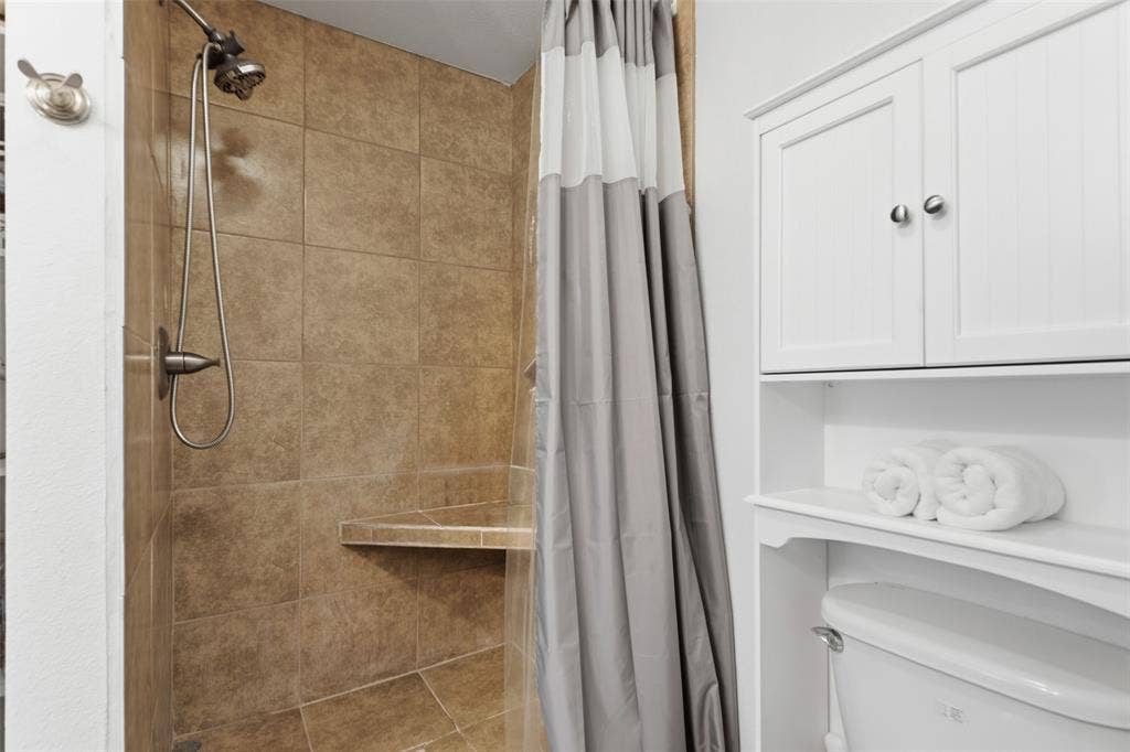 Tiled shower with a built-in bench and a brushed nickel shower head