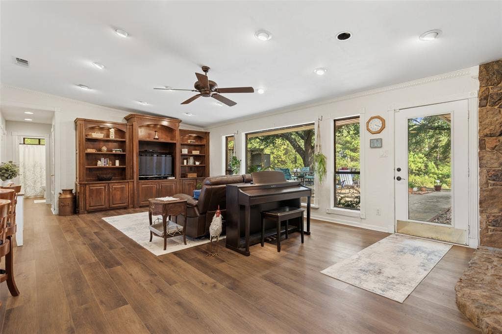 Spacious open-concept living area featuring hardwood flooring, recessed lighting, and a ceiling fan