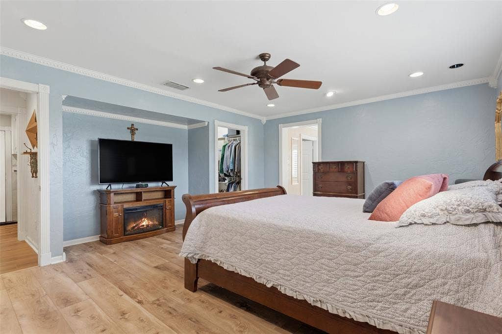 Recessed lighting, wood-finish flooring, ceiling fan, crown molding, and a built-in closet with shelving