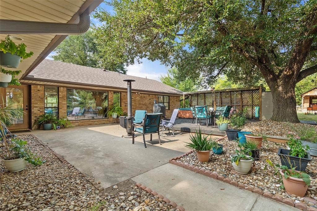 Expansive patio area featuring concrete and gravel landscaping, with a brick exterior