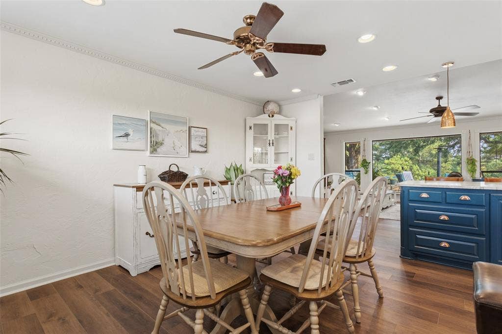 Dining area showcasing a wood-finish table with turned-leg chairs, recessed ceiling lighting, and a ceiling fan with bronze finish