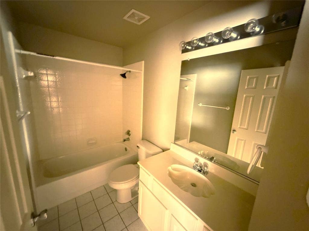 White vanity with integrated sink, chrome faucet, and overhead bar lighting