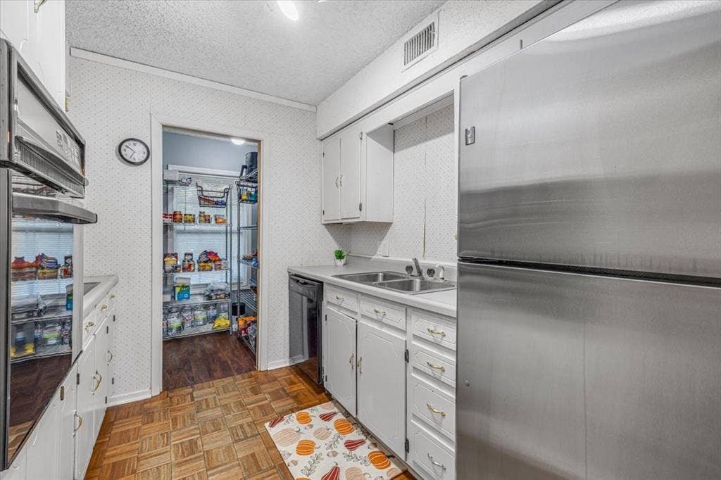 1106 Scenic Drive, Granbury, TX 76048 Kitchen featuring stainless steel refrigerator, built-in wall oven, dual-basin stainless steel sink, wood-finish parquet flooring, and white cabinetry