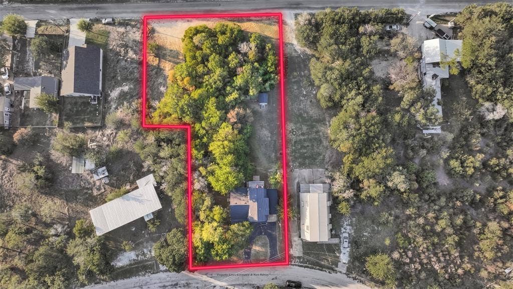 1106 Scenic Drive, Granbury, TX 76048 Aerial perspective of a multi-acre property featuring mature tree cover, a paved driveway, and established landscape
