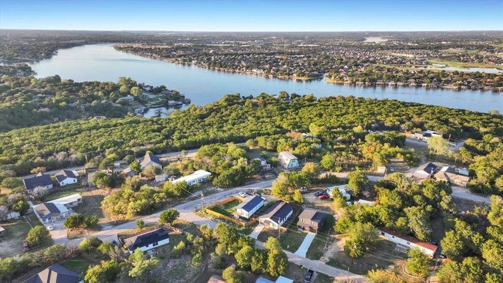1106 Scenic Drive, Granbury, TX 76048 Aerial perspective featuring expansive waterfront positioning, mature tree canopy, and established neighborhood topography