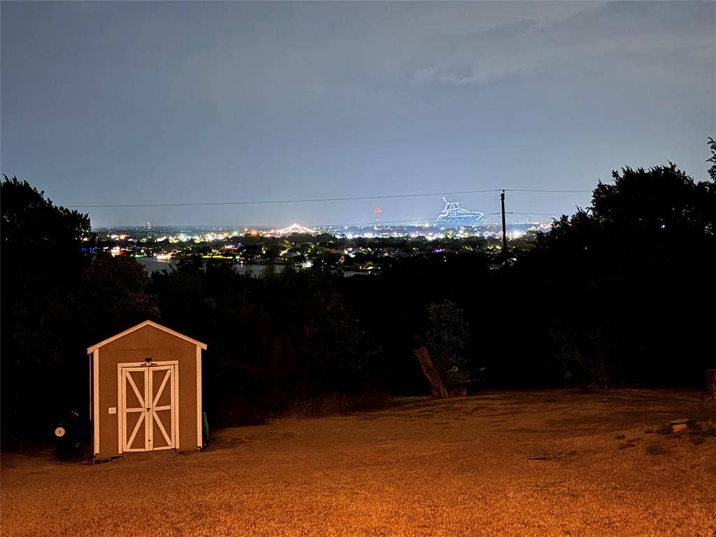 1106 Scenic Drive, Granbury, TX 76048 Expansive grounds featuring mature trees and a detached storage structure with double doors
