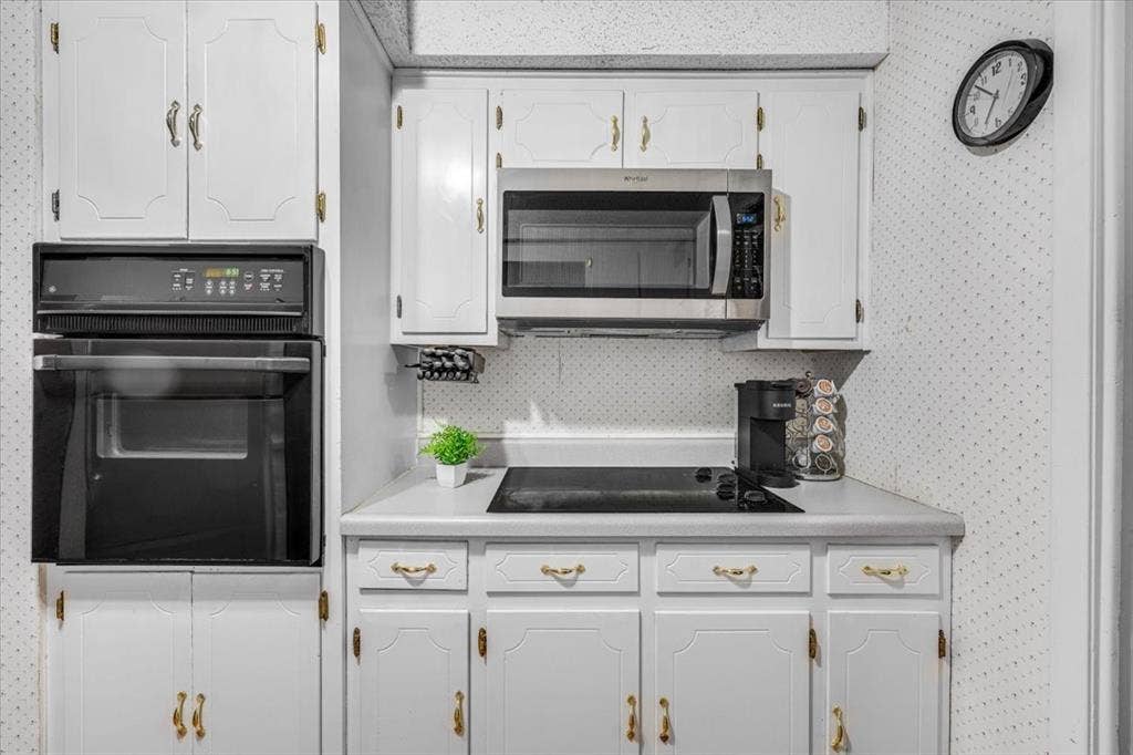 1106 Scenic Drive, Granbury, TX 76048 Kitchen featuring white cabinetry with gold-tone hardware, built-in wall oven, integrated stovetop, and over-the-range microwave