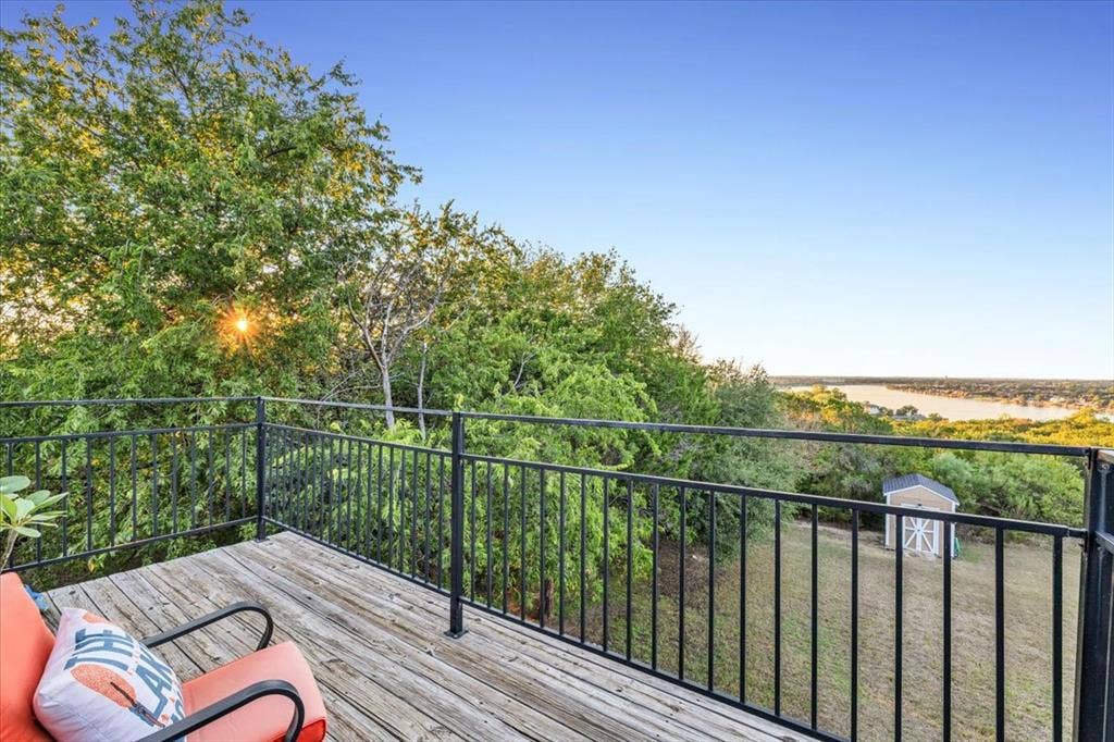 1106 Scenic Drive, Granbury, TX 76048 Elevated wood-plank deck featuring a black metal railing and expansive water scenery