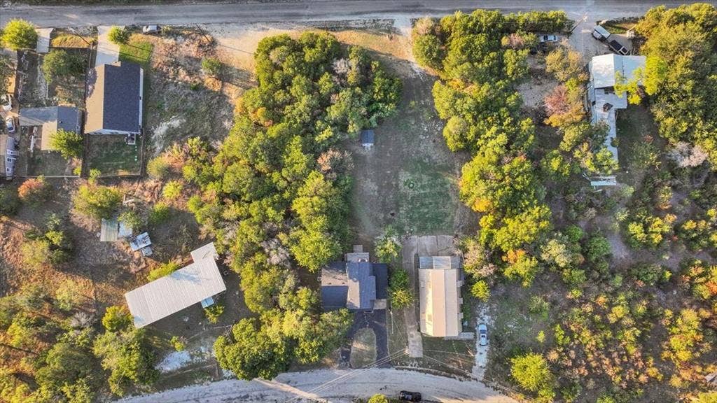 1106 Scenic Drive, Granbury, TX 76048 Aerial perspective featuring a large, expansive lot with extensive mature tree canopy and paved driveway access