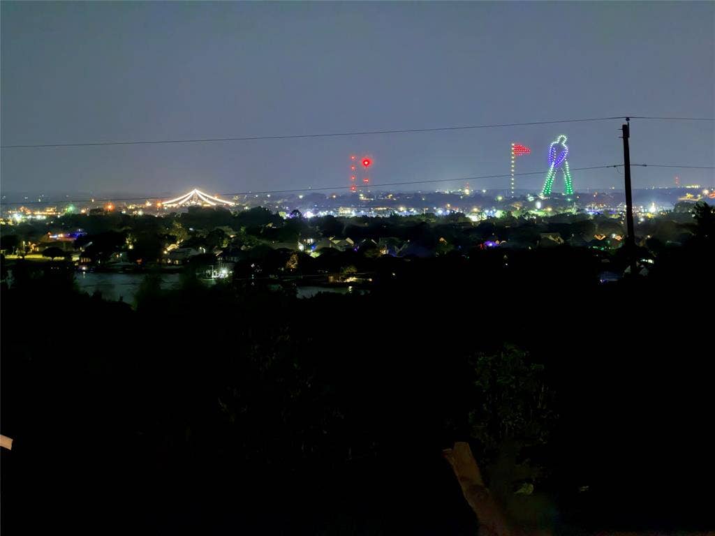 1106 Scenic Drive, Granbury, TX 76048 Elevated perspective featuring city lights, distant illuminated structures, and water
