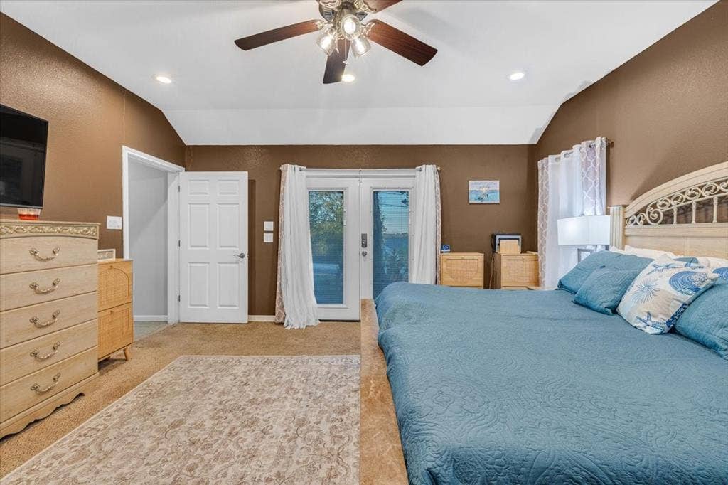 1106 Scenic Drive, Granbury, TX 76048 Vaulted ceiling with a central multi-blade ceiling fan and recessed lighting, paired with double glass-panel doors providing external access