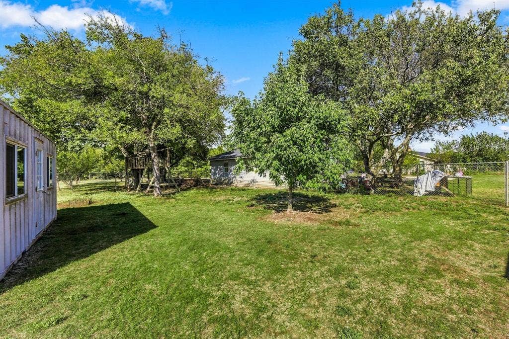 1320 Apple Lane, Midlothian, TX 76065 Expansive backyard featuring mature trees, chain-link perimeter fencing.