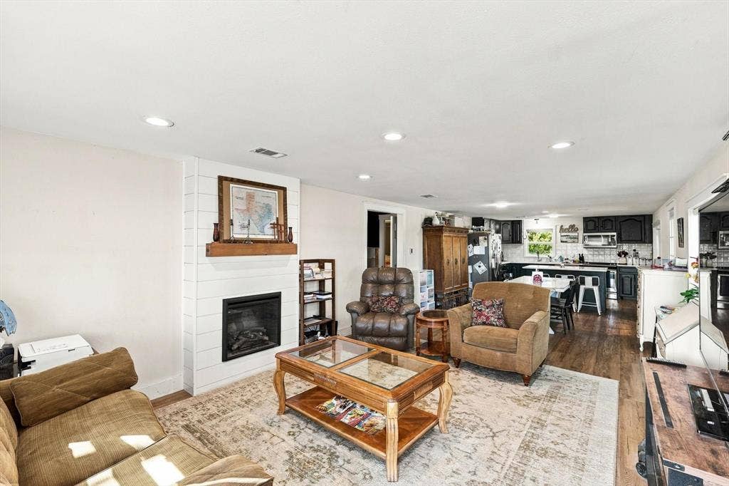 1320 Apple Lane, Midlothian, TX 76065 Living area featuring wood-finish flooring, recessed lighting, and a fireplace with a white shiplap surround and a wood mantel