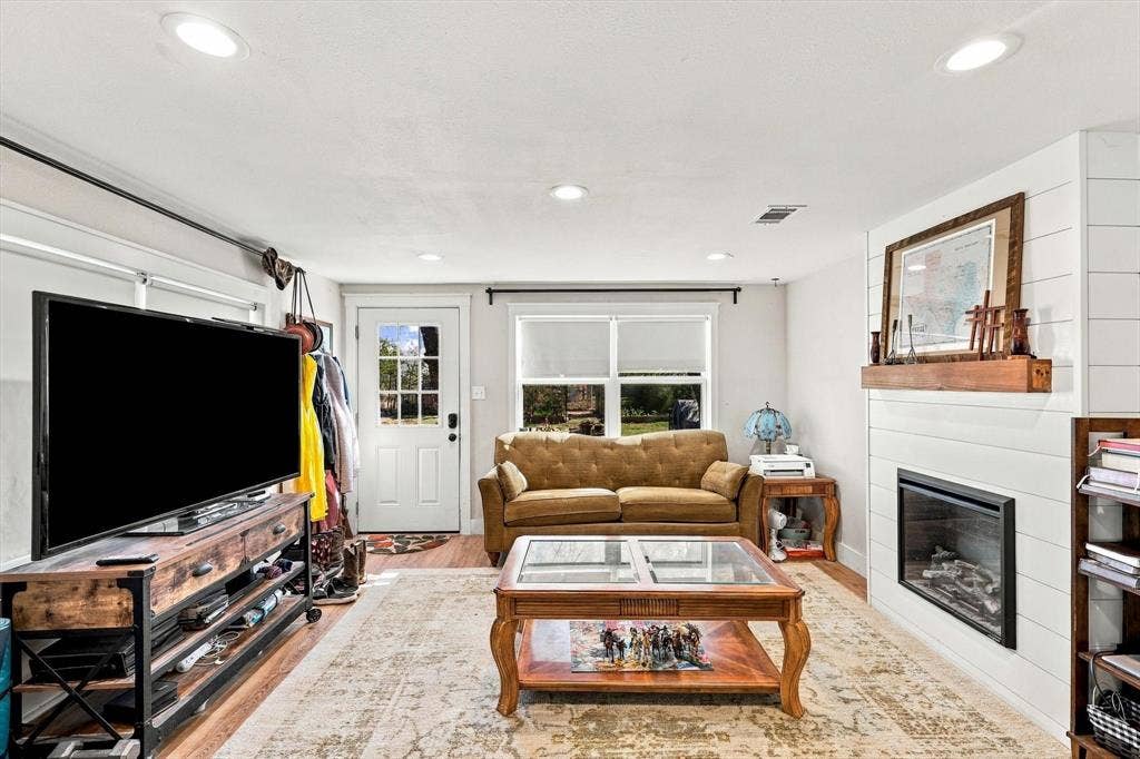 1320 Apple Lane, Midlothian, TX 76065 Fireplace featuring a wood mantel and shiplap surround, recessed lighting, and wood-finish flooring