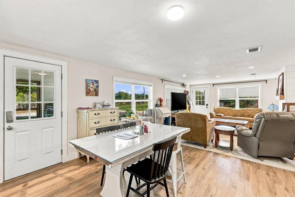 1320 Apple Lane, Midlothian, TX 76065 Open-concept interior featuring wood-finish flooring, multi-pane glass entry doors, recessed lighting, and large windows