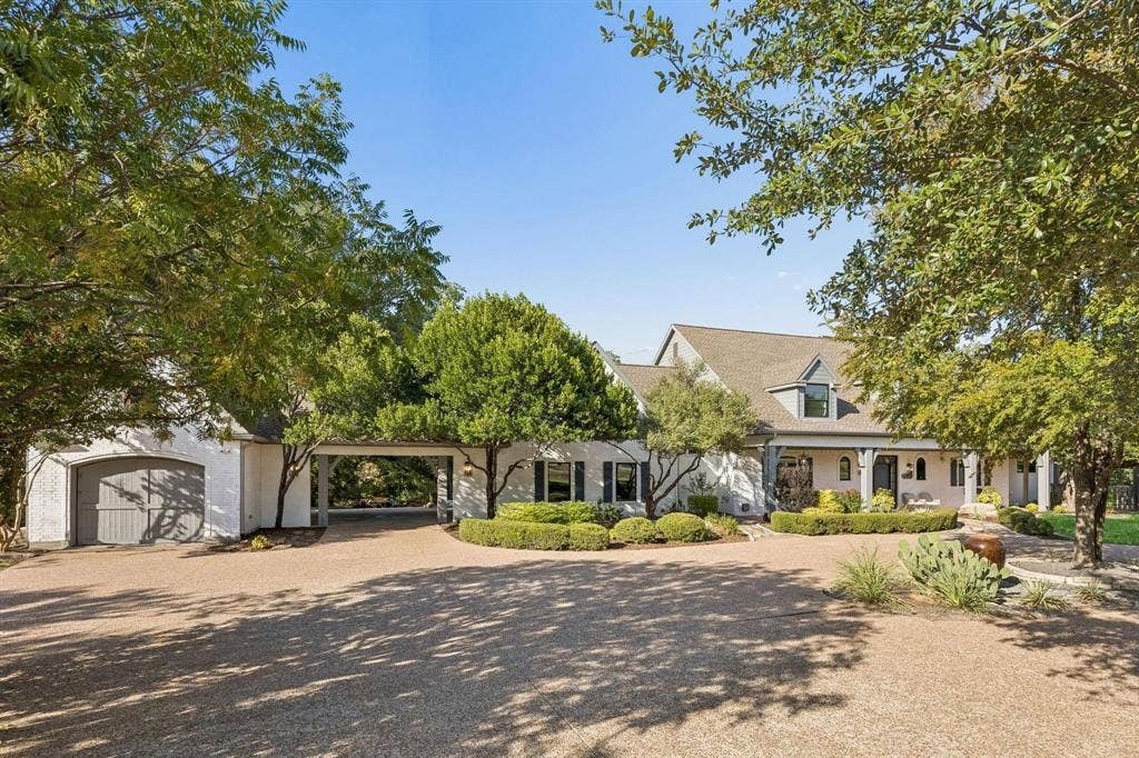 7750 Cottonwood Street, Frisco, TX 75033 Porte cochère and expansive driveway provide a grand arrival. Separate garage offers an exceptional workshop setup with abundant space for hobbies, storage or a car enthusiast.