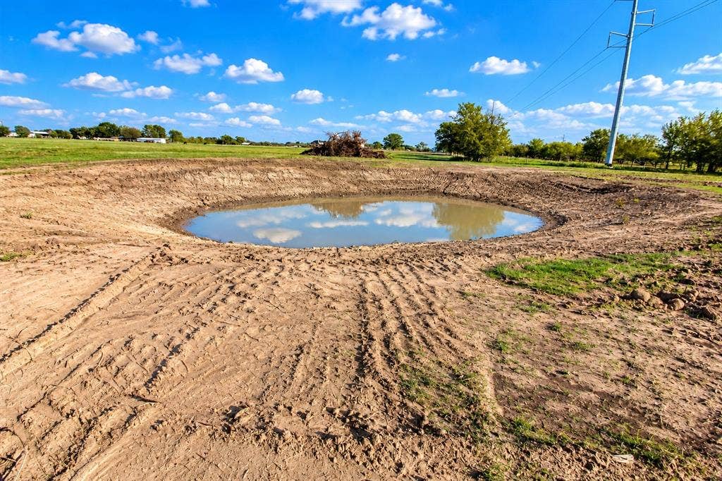 7697 County Road 4094, Scurry, TX 75158 Expansive open acreage featuring a natural earthen pond and cleared terrain