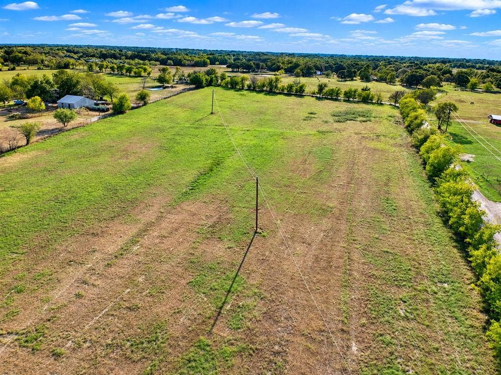 7697 County Road 4094, Scurry, TX 75158 Expansive acreage featuring cleared pasture land, mature perimeter tree lines, and open horizon