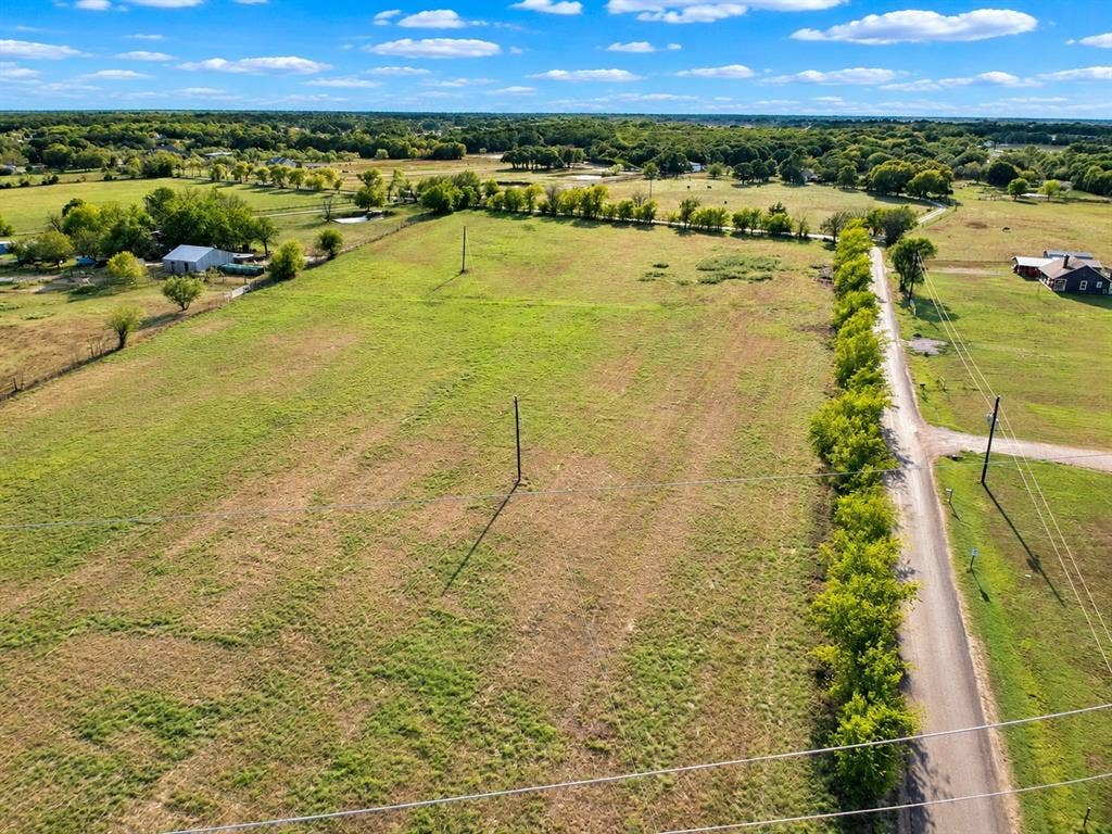 7697 County Road 4094, Scurry, TX 75158 Expansive acreage featuring cleared pasture land, established tree-lined boundaries, and direct gravel road access