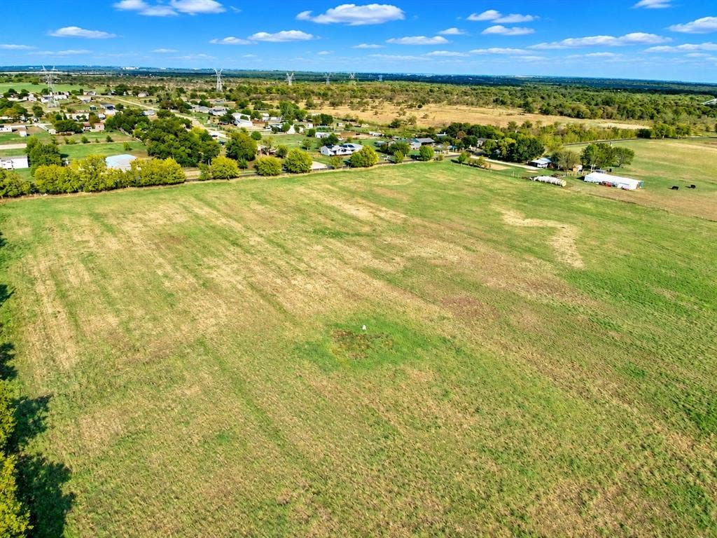 7697 County Road 4094, Scurry, TX 75158 Expansive open acreage featuring cleared grass terrain, level topography, and mature tree-lined borders