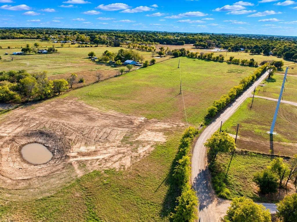 7697 County Road 4094, Scurry, TX 75158 Expansive acreage featuring cleared pasture land, a private pond, and tree-lined perimeter