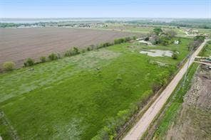 Lot 3 Bozek Lane, Ennis, TX 75119 Expansive green fields with a dirt road, bordering a plowed field