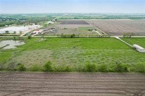 Lot 3 Bozek Lane, Ennis, TX 75119 Expansive agricultural land featuring a large open field, a small pond, and a detached outbuilding