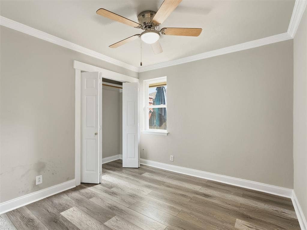 1402 Addington Street, Irving, TX 75062 Wood-finish flooring, crown molding, ceiling fan with integrated lighting, and a double-door closet