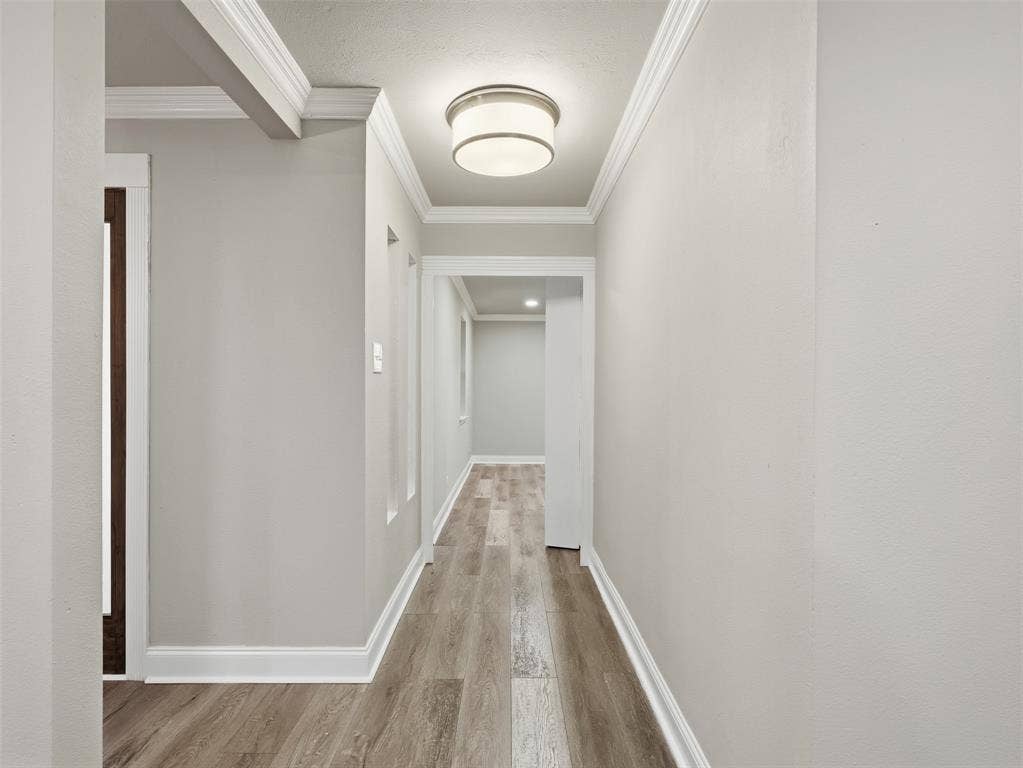 1402 Addington Street, Irving, TX 75062 Hallway with wood-finish flooring, crown molding, and a drum ceiling light fixture