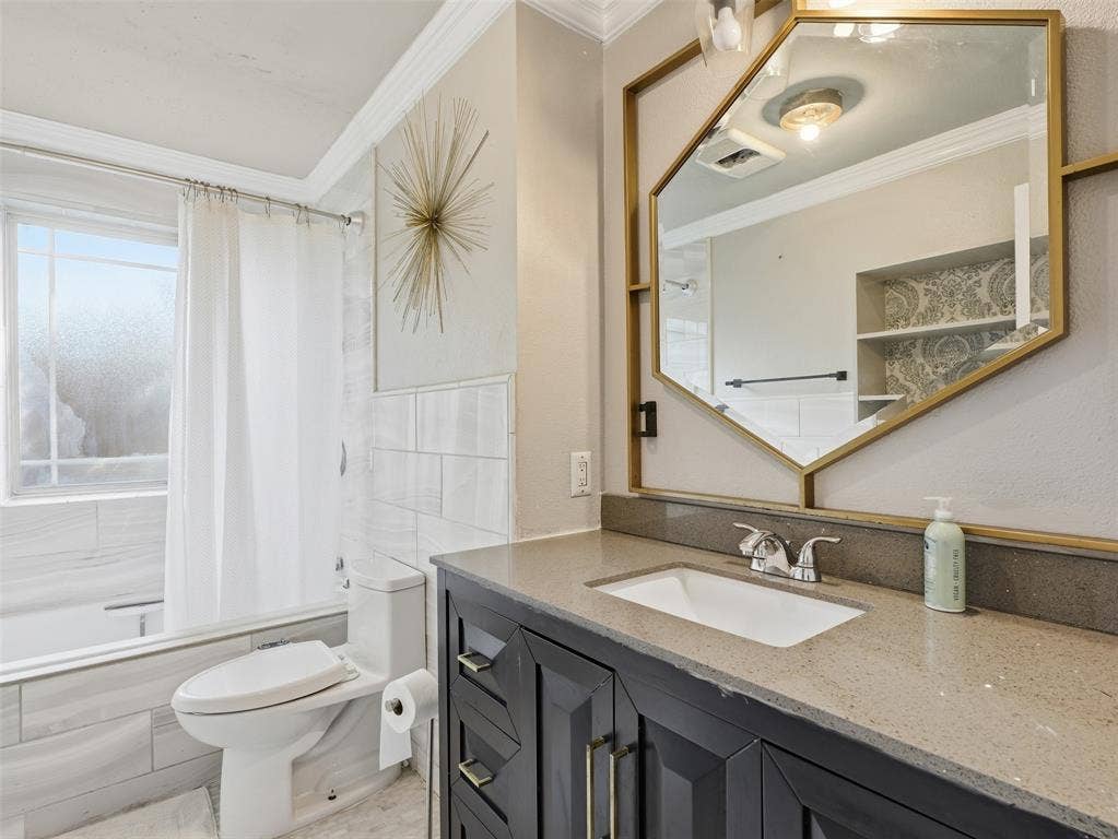 1402 Addington Street, Irving, TX 75062 Vanity with a light-toned countertop, under-mount sink, and dark cabinetry