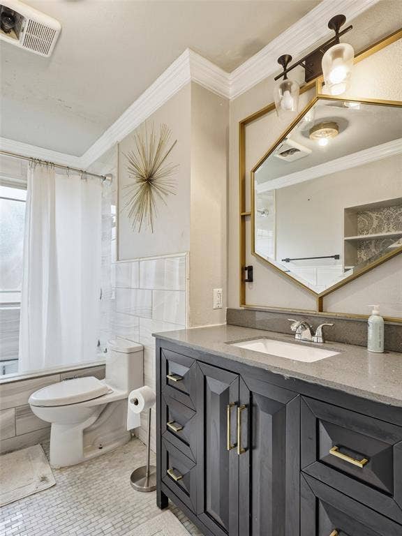 1402 Addington Street, Irving, TX 75062 Dark wood-finish vanity with gold-tone hardware, rectangular undermount sink, and a stone countertop