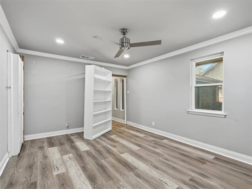 1402 Addington Street, Irving, TX 75062 Wood-finish flooring, recessed lighting, crown molding, ceiling fan, and built-in shelving