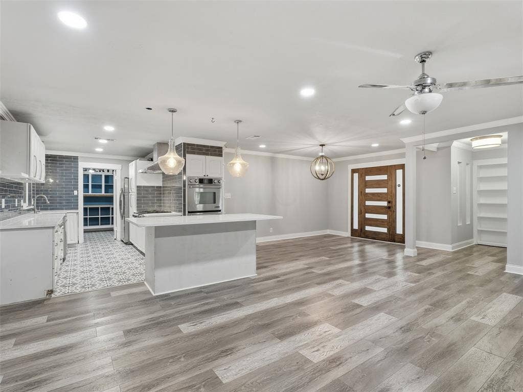 1402 Addington Street, Irving, TX 75062 Expansive open-concept living space with wood-finish flooring, recessed lighting, and a modern ceiling fan