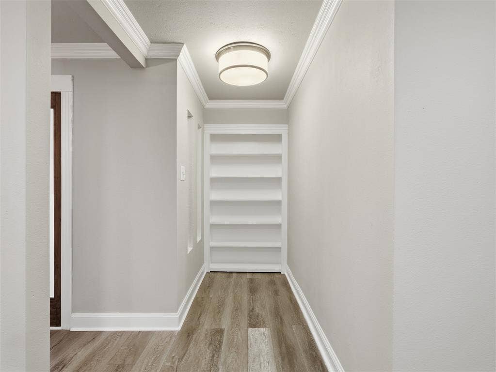 1402 Addington Street, Irving, TX 75062 Hallway featuring built-in shelving, wood-finish flooring, recessed lighting, and crown molding