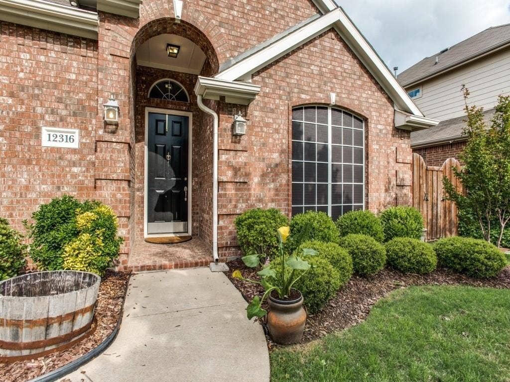 12316 Sailmaker Lane, Frisco, TX 75035 Brick facade with an arched entry, a dark paneled front door, and an arched window