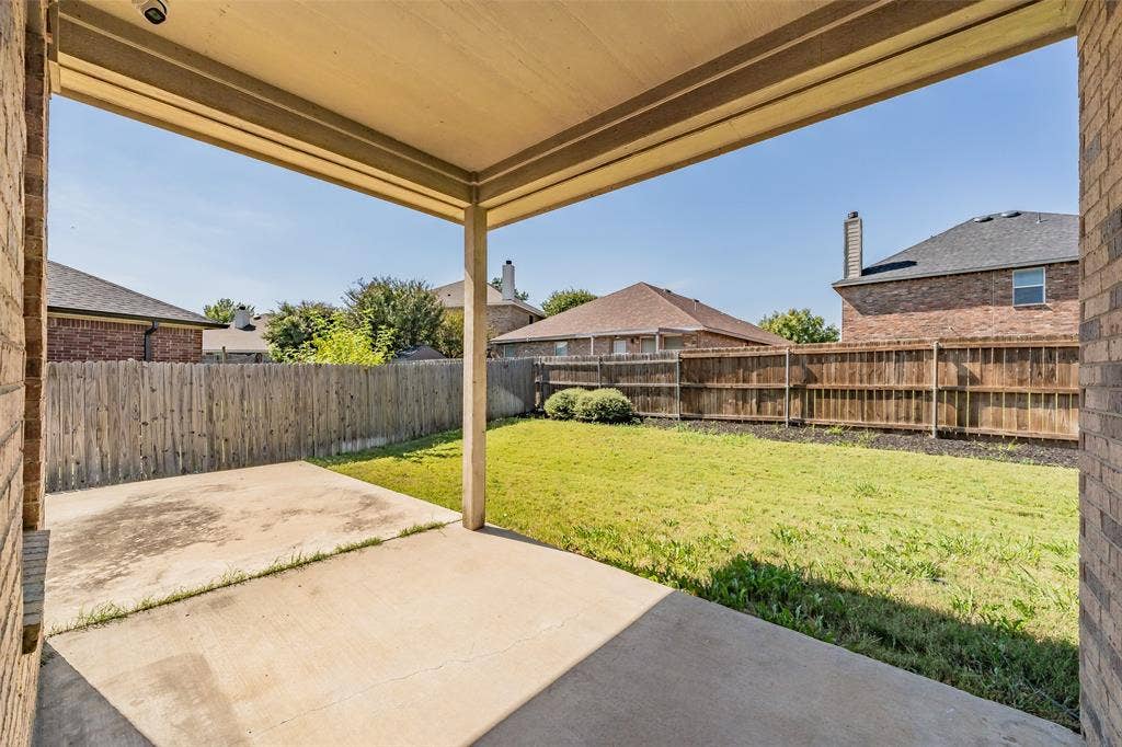 2205 Clairborne Drive, Fort Worth, TX 76177 Covered patio with a concrete slab, overlooking a fenced backyard with a grass lawn