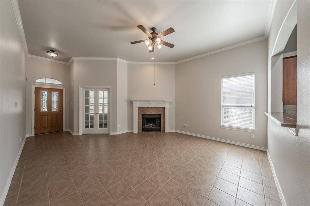 2205 Clairborne Drive, Fort Worth, TX 76177 Spacious living area showcasing neutral wall finishes, a ceiling fan with integrated lighting, a wood-burning fireplace with surround, and diagonal-pattern tile flooring