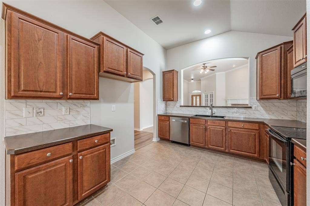 2205 Clairborne Drive, Fort Worth, TX 76177 Kitchen featuring wood cabinetry, tile flooring, and stainless steel appliances