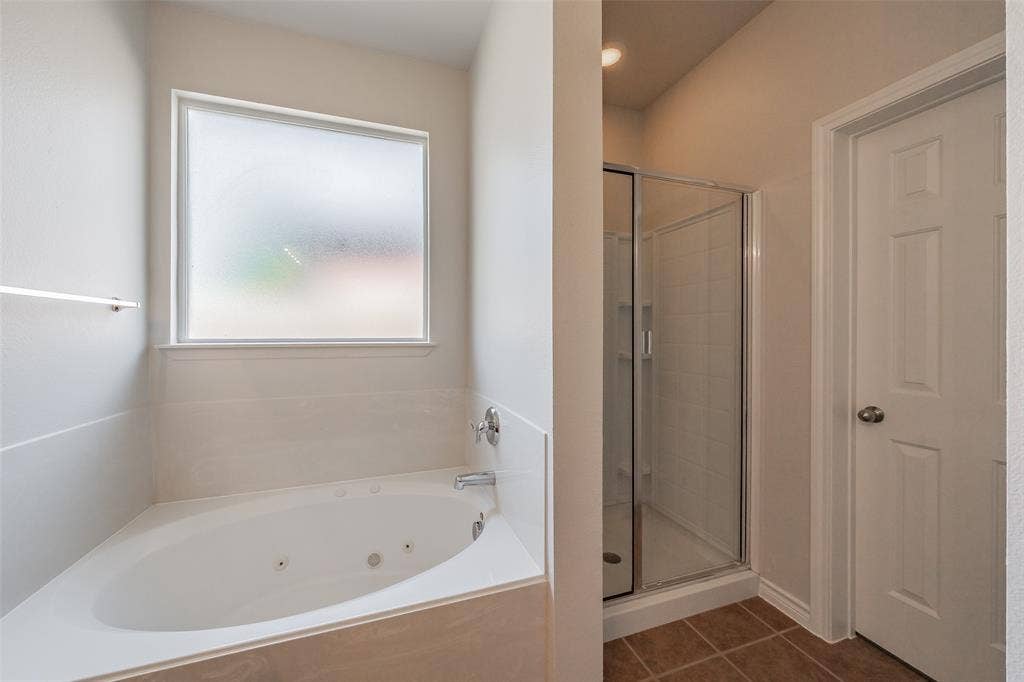 2205 Clairborne Drive, Fort Worth, TX 76177 Corner soaking tub with frosted window, separate glass-enclosed shower, and tile flooring