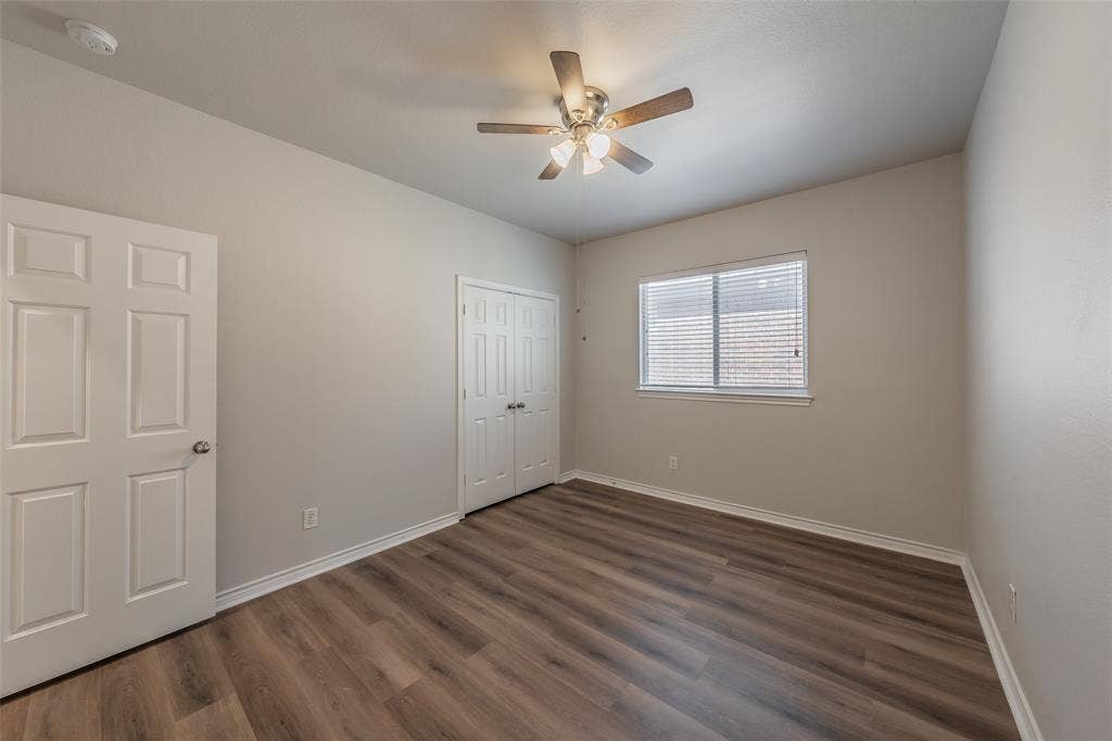 2205 Clairborne Drive, Fort Worth, TX 76177 Wood-finish flooring, ceiling fan with integrated lighting, window with blinds, and bi-fold closet doors