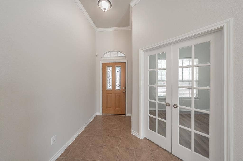2205 Clairborne Drive, Fort Worth, TX 76177 Entryway featuring tiled flooring, a wooden front door with decorative glass inserts, an arched transom window, and white French doors with glass panels