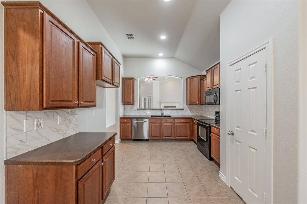 2205 Clairborne Drive, Fort Worth, TX 76177 Kitchen featuring wood cabinetry, integrated appliances, ceramic tile flooring, and a stone-look backsplash