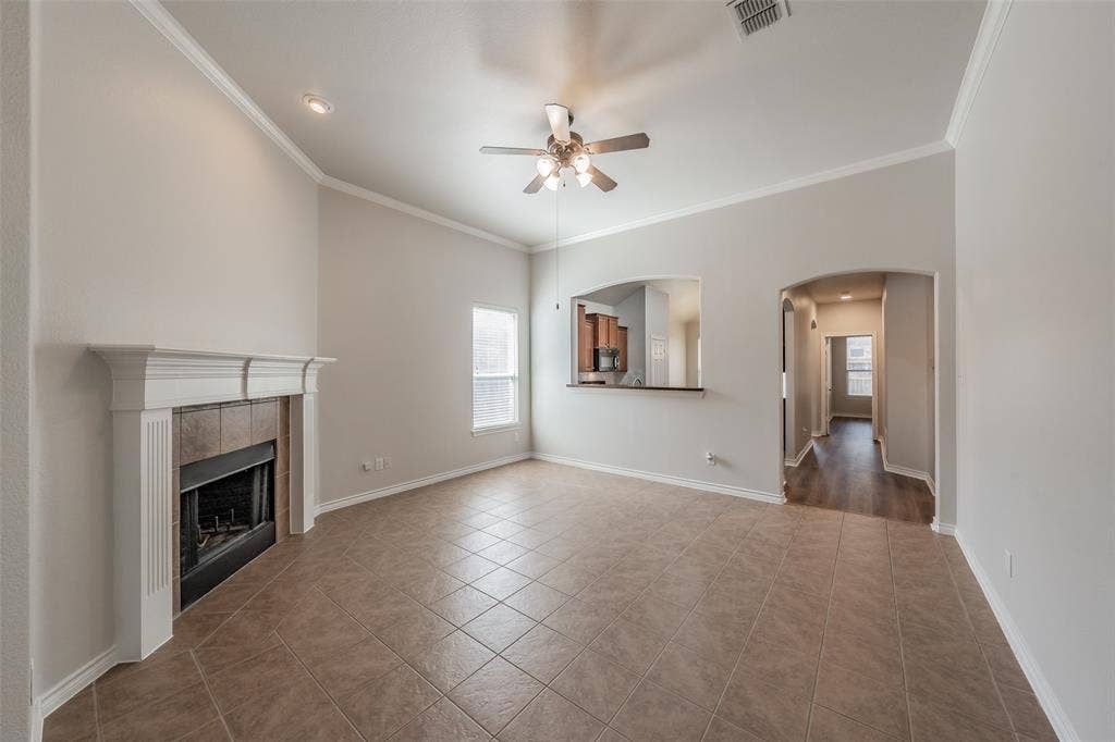 2205 Clairborne Drive, Fort Worth, TX 76177 Vaulted ceiling with crown molding, tile flooring, and a fireplace with a mantel