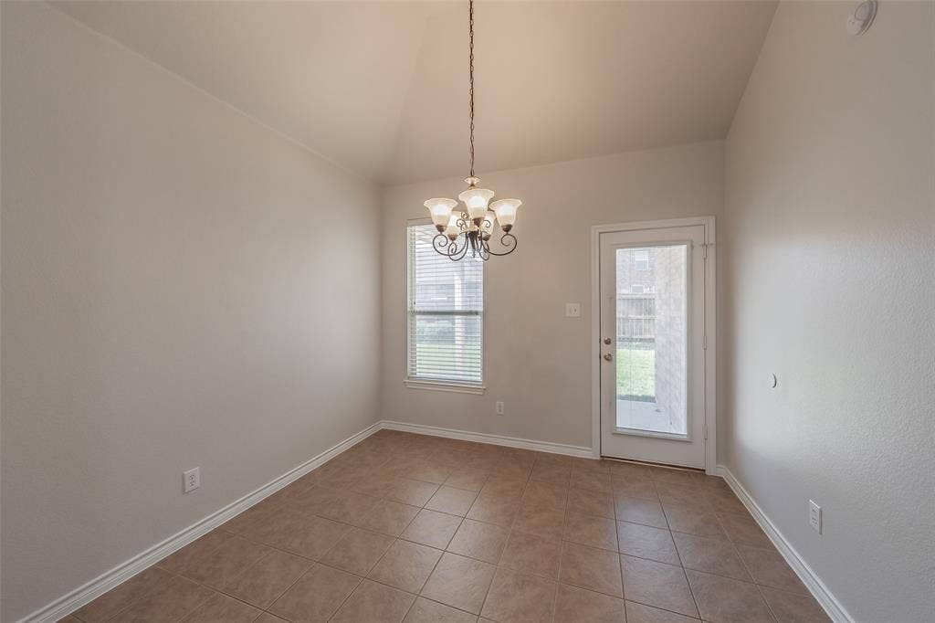 2205 Clairborne Drive, Fort Worth, TX 76177 Vaulted ceiling with an elegant chandelier, tiled flooring, window with blinds, and a glass-paneled door to the exterior