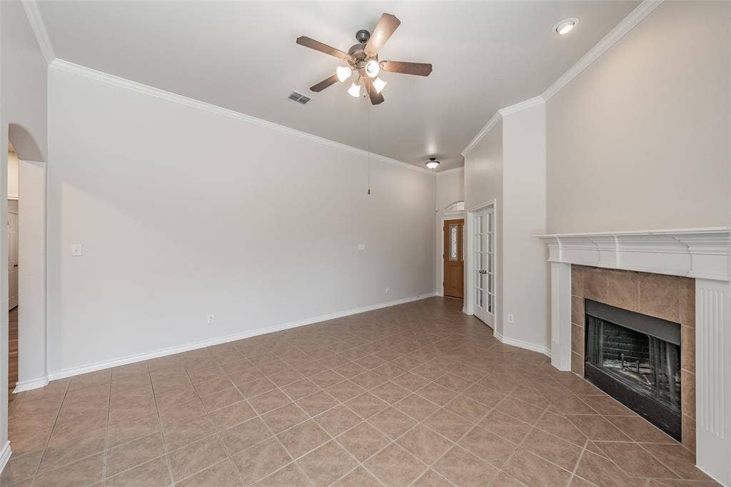 2205 Clairborne Drive, Fort Worth, TX 76177 Tile flooring, crown molding, ceiling fan, recessed lighting, and a fireplace with a white mantel