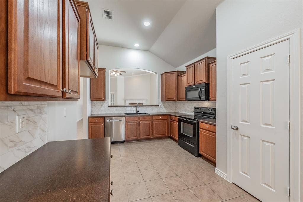 2205 Clairborne Drive, Fort Worth, TX 76177 Kitchen featuring wood cabinetry, stainless steel dishwasher, black range, black microwave, and tile flooring